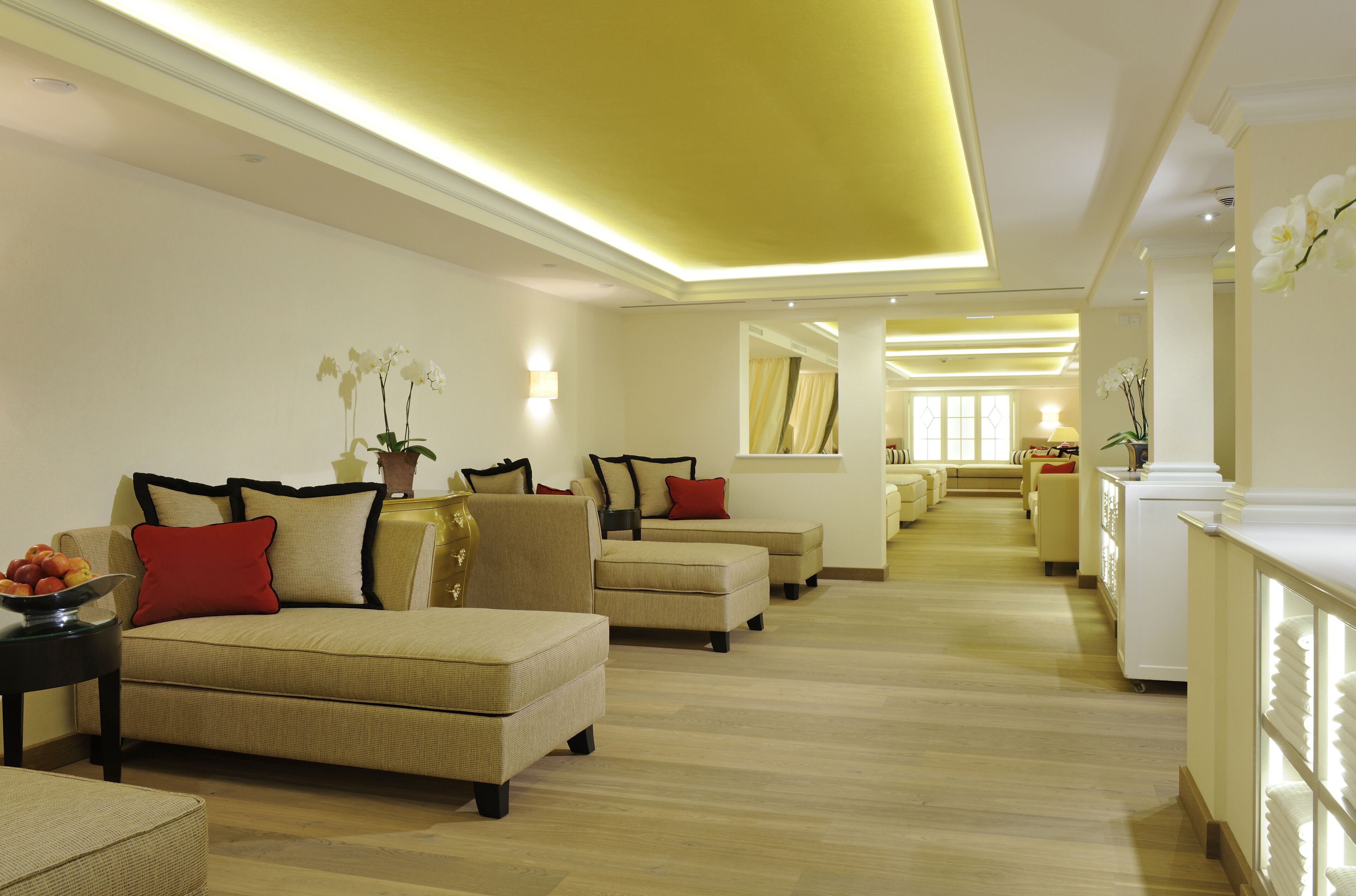 Un amplio vestíbulo de hotel con varias zonas de estar, una recepción y un techo bien iluminado.