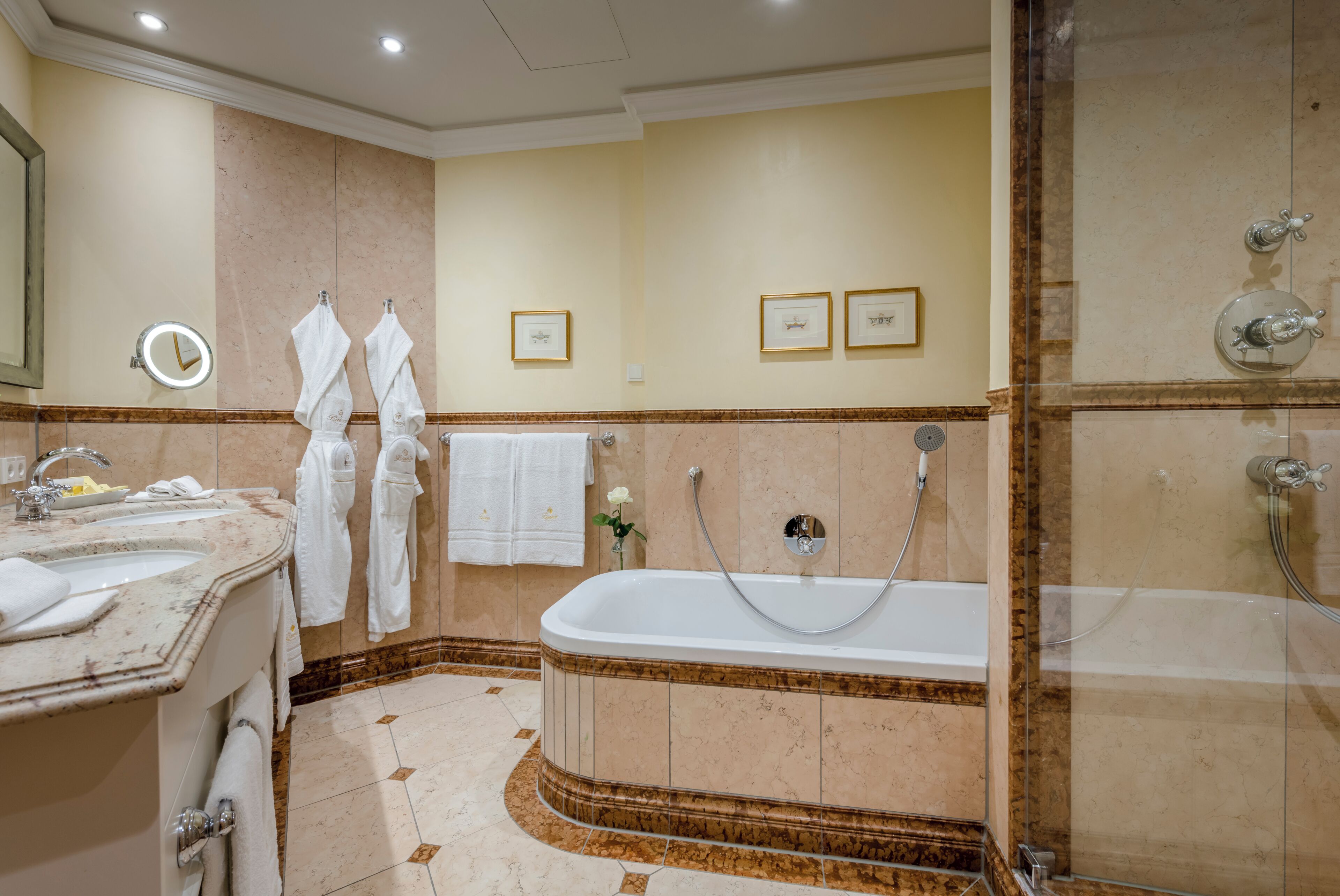 A hotel bathroom with a bathtub, a shower, and a vanity with a sink.