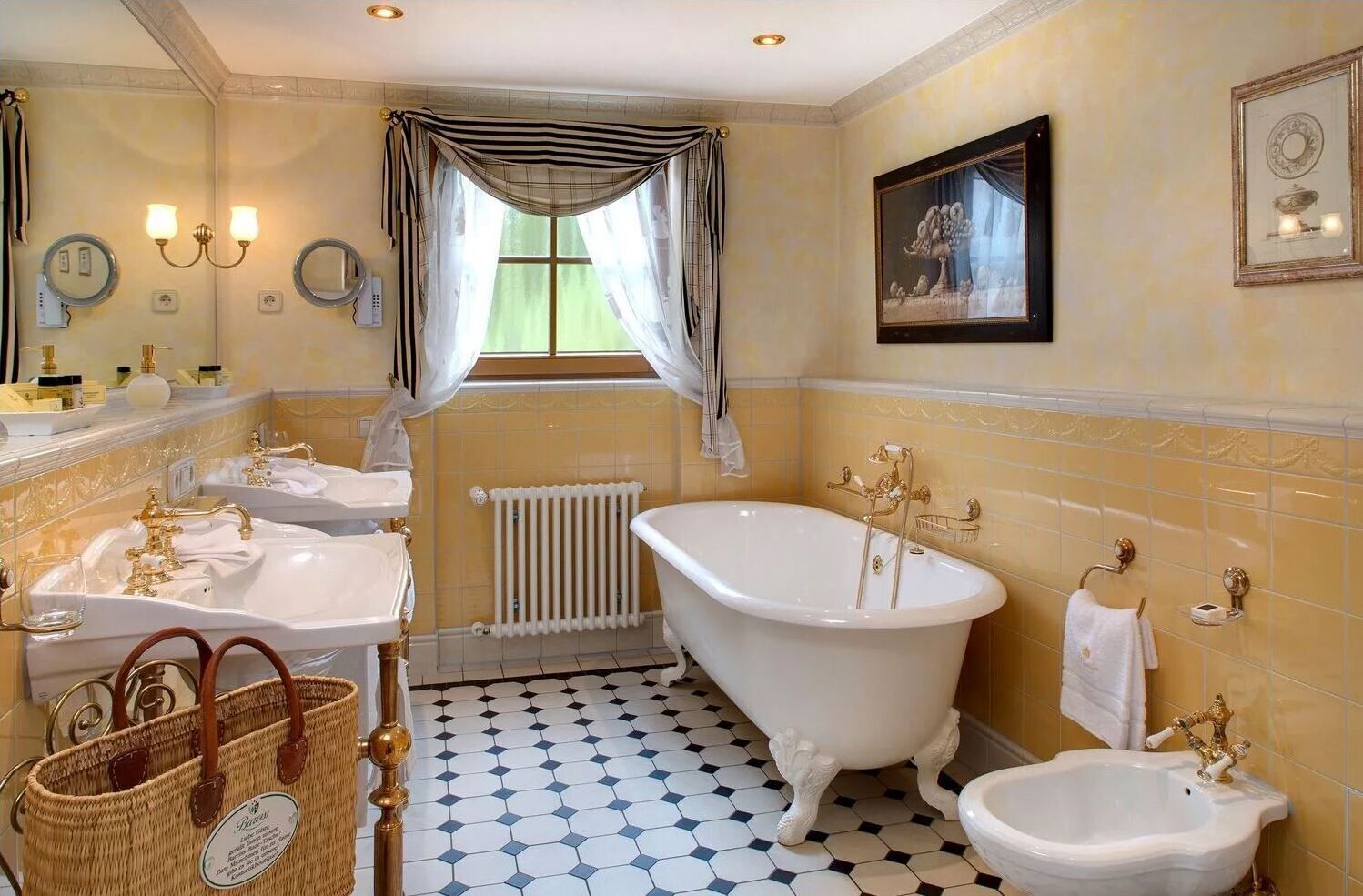 Un baño con dos lavamanos, una bañera, un radiador y suelo de baldosas.