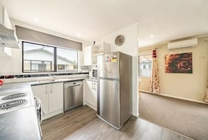 Enjoy cooking in this well-equipped kitchen with a refrigerator, stove, and ample natural light.