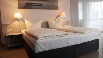 A hotel room with a large bed, two bedside lamps, a nightstand, and a painting on the wall.
