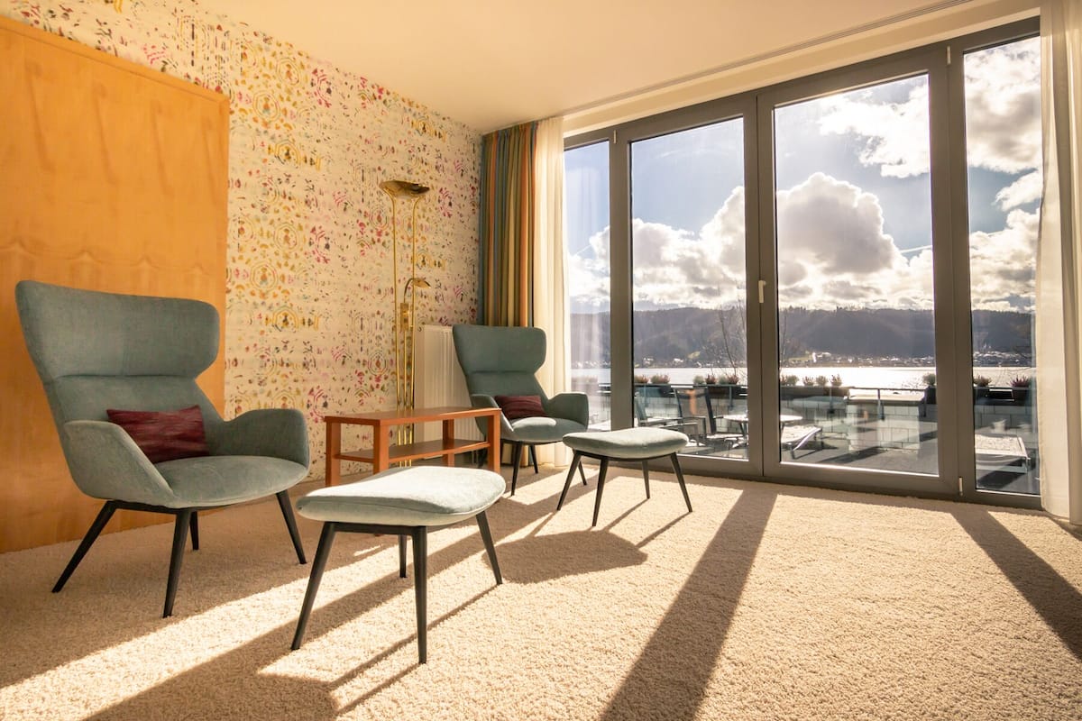 Quarto amplo com uma grande porta de vidro deslizante que dá para uma varanda com vista panorâmica das montanhas.