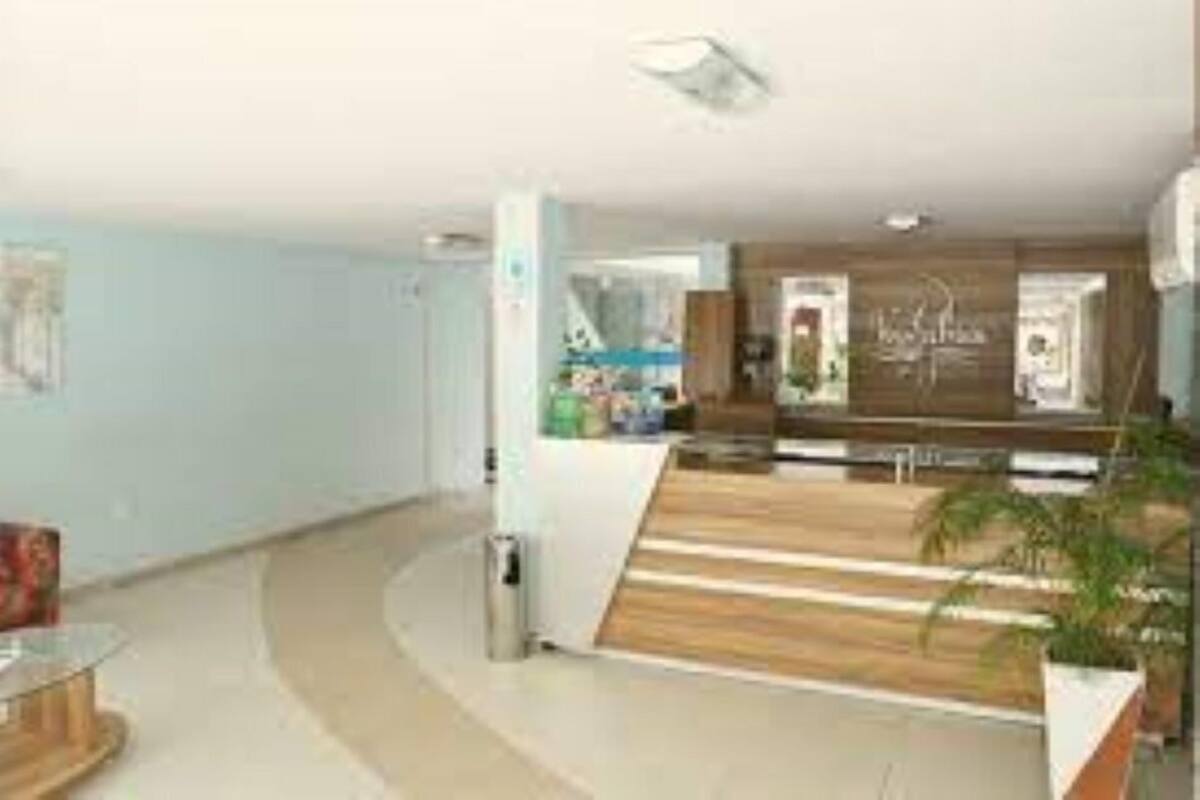 A reception area with a curved desk, a trash bin, and a potted plant.