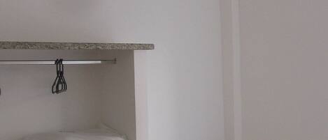A bathroom with a ceiling fan, a towel rack, and a tiled shower area.