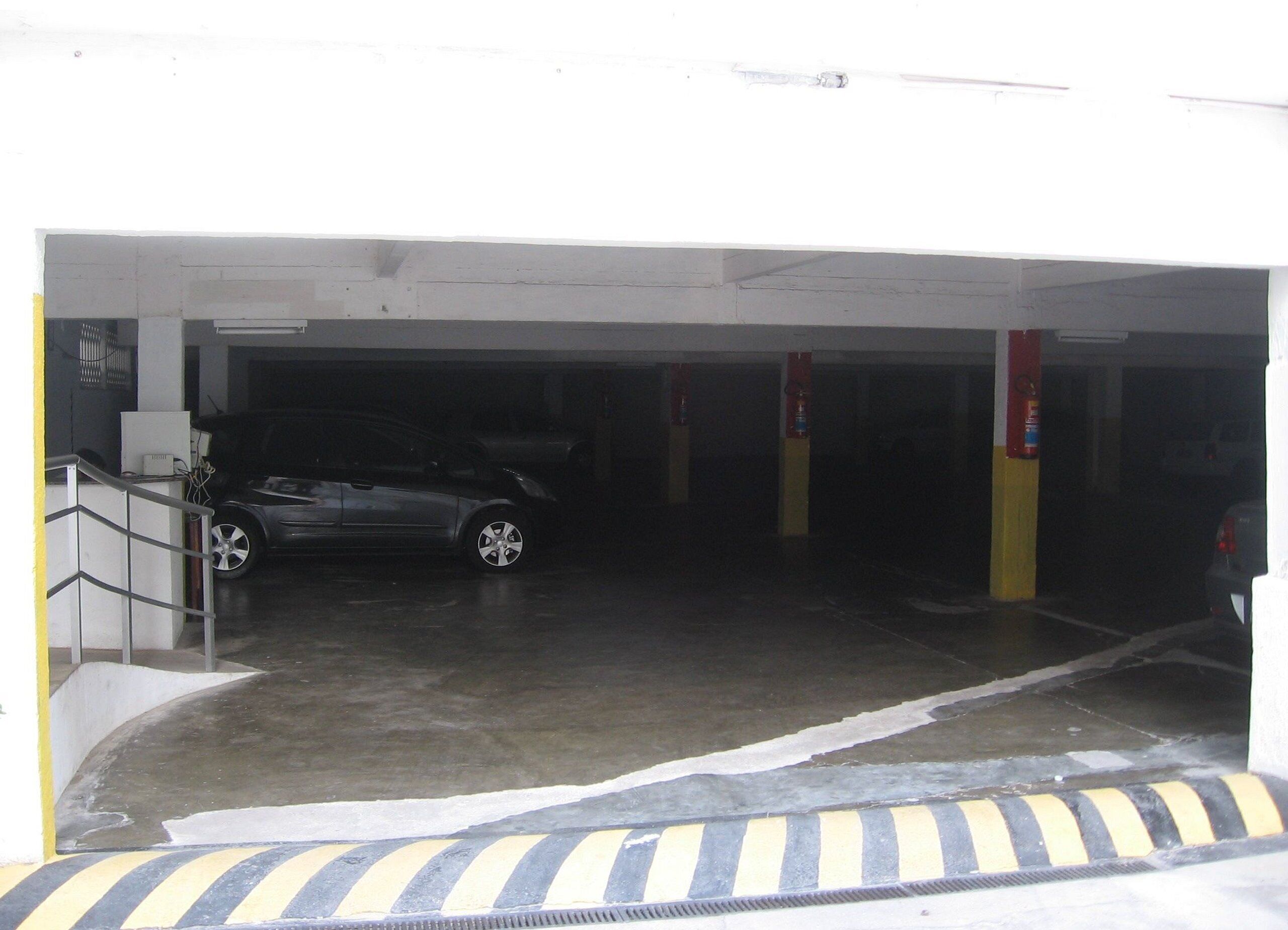 En parkeringskælder med en parkeret bil.