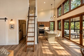 A spacious kitchen with a central island, wooden flooring, and large windows. - Pushin' Time Hideaway at The Retreat at Water's Edge (Tracy City)