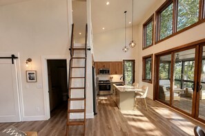 Une cuisine moderne avec des meubles en bois, un îlot central et des luminaires suspendus.