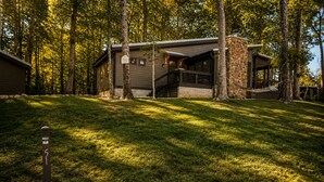 Een vakantiehuis met een stenen gevel, een overdekte veranda en een gazon.