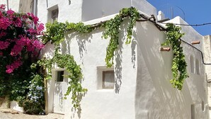 A white building with a stone foundation, a small window, and a door.