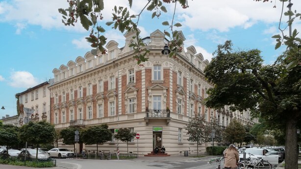 Ein historisches Gebäude im klassischen Stil, mit einem markanten Eingang und einem Balkon.