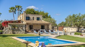 A stone villa with a swimming pool, outdoor seating, and palm trees. - Villa Can Cosme (Alcúdia)