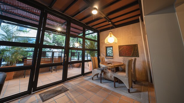A spacious room with large windows, a round wooden table, and a ceiling light fixture. - Cozy 1BR APT in the Heart of Medellin (Medellín)