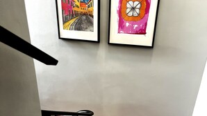 Una escalera con piso de madera y dos obras de arte enmarcadas en la pared.