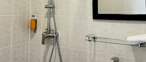 A bathroom with a shower, sink, and mirror.