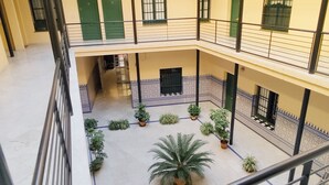 Een meerlaags atrium met een centrale binnenplaats, met potplanten en een palmboom.