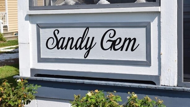 Una casa con un cartello che riporta la scritta "Sandy Gem".