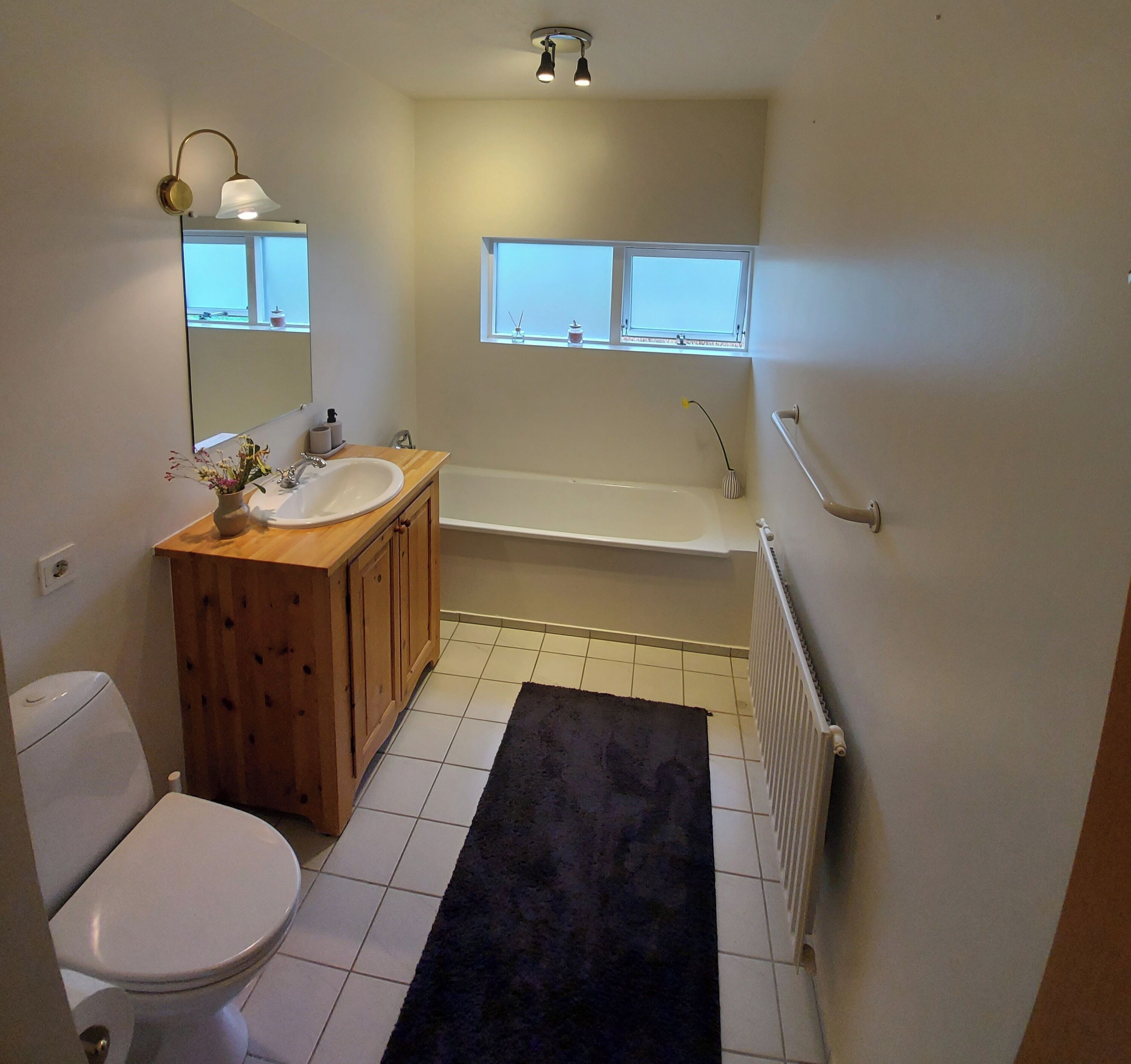 Un baño con inodoro, lavamanos, tocador, bañera y ventana.