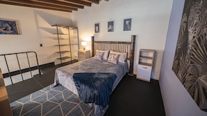 A bedroom with a bed, bedside tables, a nightstand, a lamp, and a wall-mounted shelf. - BEST Location 1BedR - Heart of Medellin (Medellín)