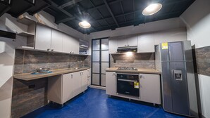 A modern kitchen with stainless steel appliances, a blue floor, and a dark ceiling. - BEST Location 1BedR - Heart of Medellin (Medellín)