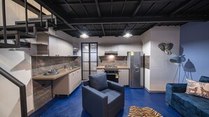 A compact living space with a kitchen, a sofa, a chair, and a zebra-patterned rug. - BEST Location 1BedR - Heart of Medellin (Medellín)