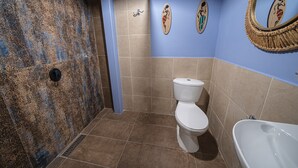 A bathroom with a patterned wall, a toilet, a bathtub, and a mirror with surfboard decorations. - BEST Location 1BedR - Heart of Medellin (Medellín)