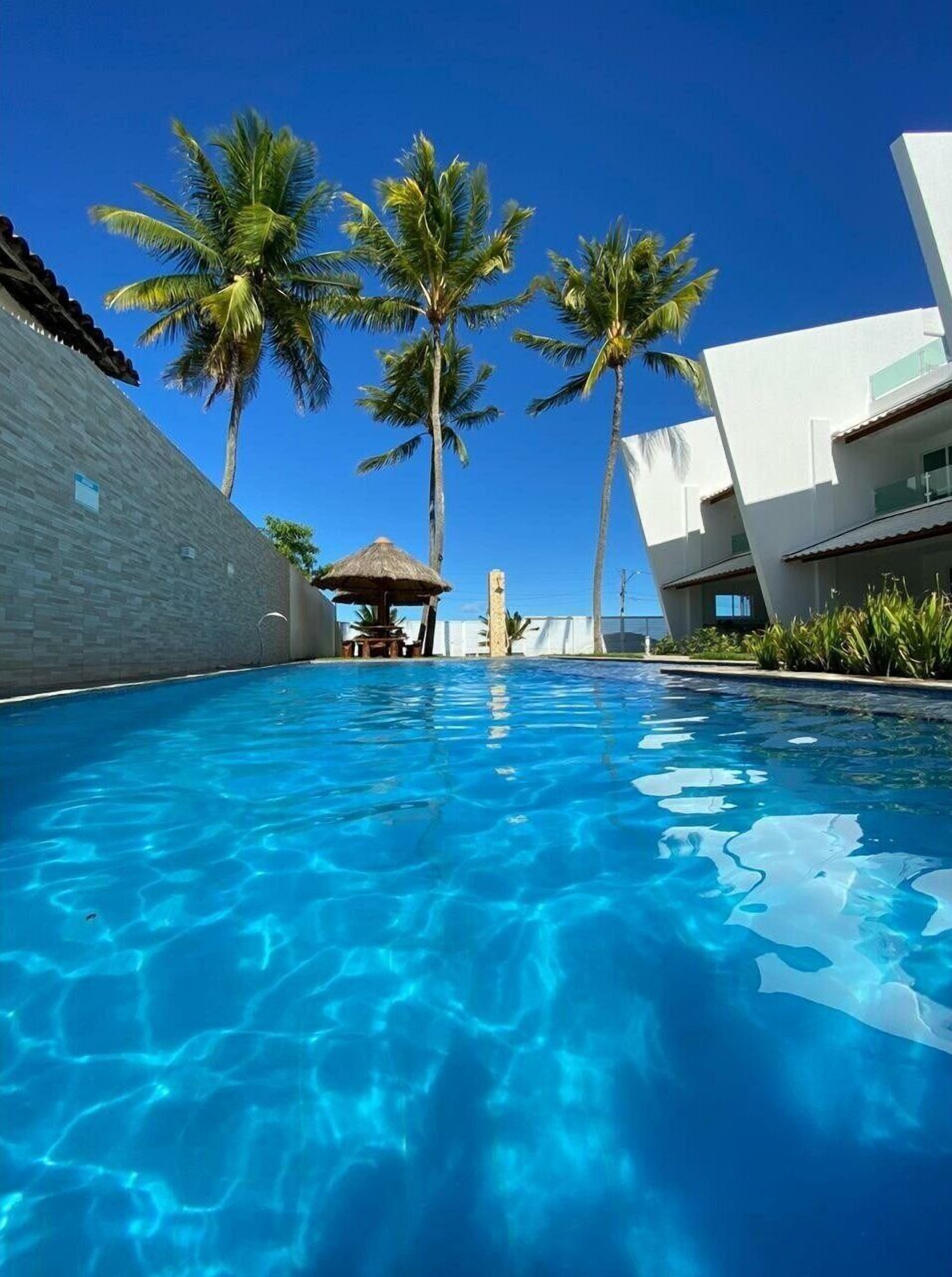 Una piscina al aire libre, camas de piscina gratis, sombrillas