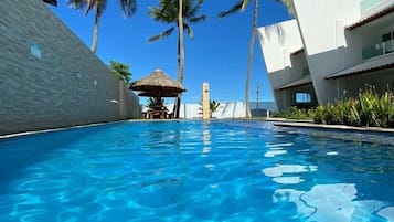 Una piscina al aire libre, camas de piscina gratis, sombrillas
