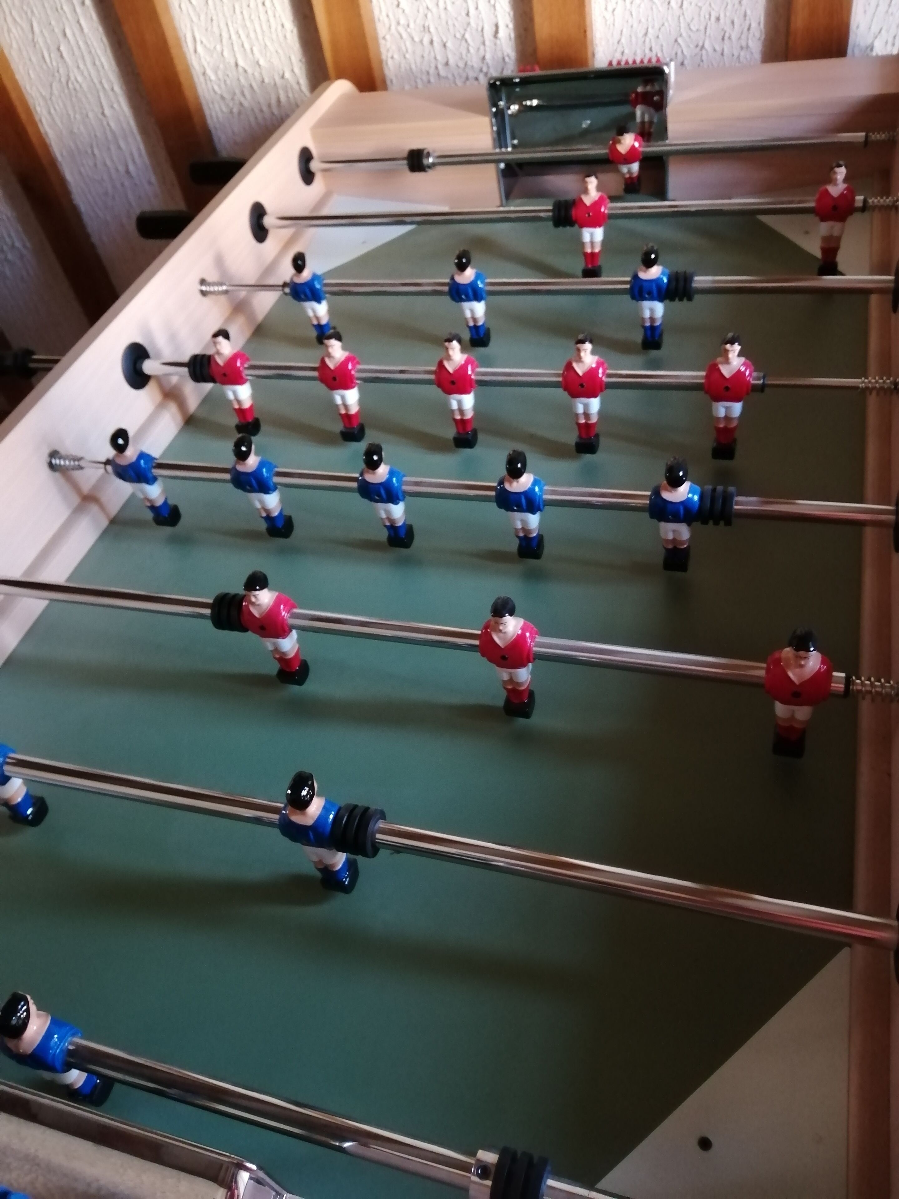 A foosball table with players in red and blue uniforms.