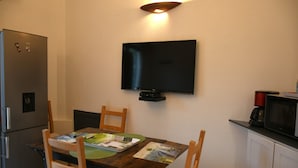 Cocina compacta con televisión integrada, refrigerador y microondas.