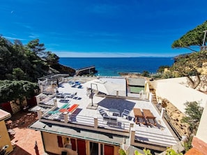 A rooftop terrace with outdoor seating and a view of the sea.