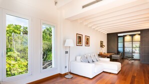 A modern living room with a white sofa, large windows, and a wooden floor. - 'Luxury Villa Larios Torrequebrada' with Sea View, Pool & Wi-Fi (Benalmádena)