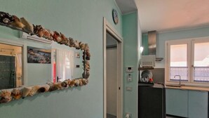 Eine kompakte Küche mit Mikrowelle, kleinem Kühlschrank und einem Fenster mit Blick.