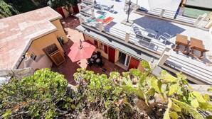 Ein Küstenanwesen mit Dachterrasse, Sitzgelegenheiten im Freien und Meerblick.