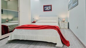 Ein Schlafzimmer mit Bett, Nachttisch, Schrank und einem Gemälde an der Wand.