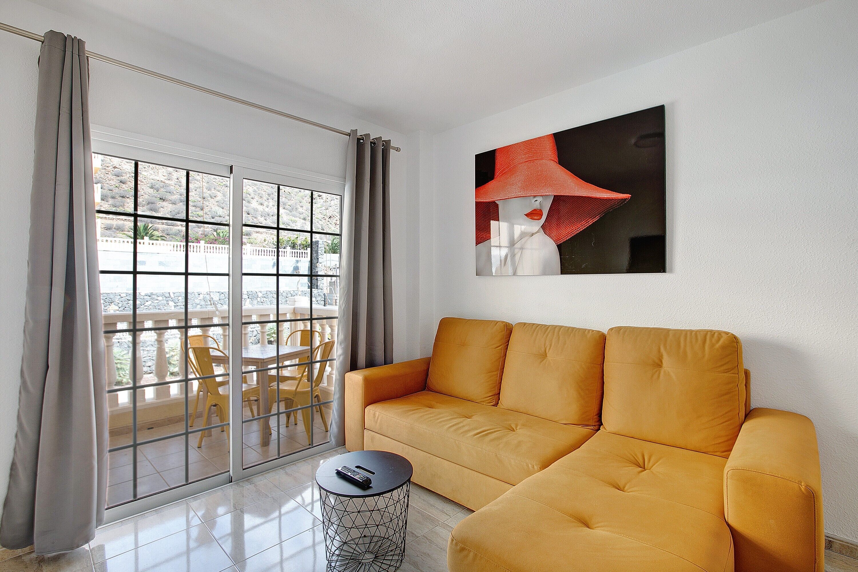 A living room with a sofa, a round coffee table, and a painting on the wall.