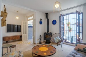 A living room with a TV, sofa, round coffee table, and a fireplace.