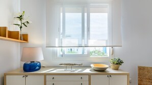 Ein Zimmer mit einem Holzkabinett, einer Lampe, einer Fischdekoration und einem Fenster mit Blick auf Grünflächen.
