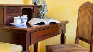 Un escritorio de madera con un libro, una jarra y dos tazas.