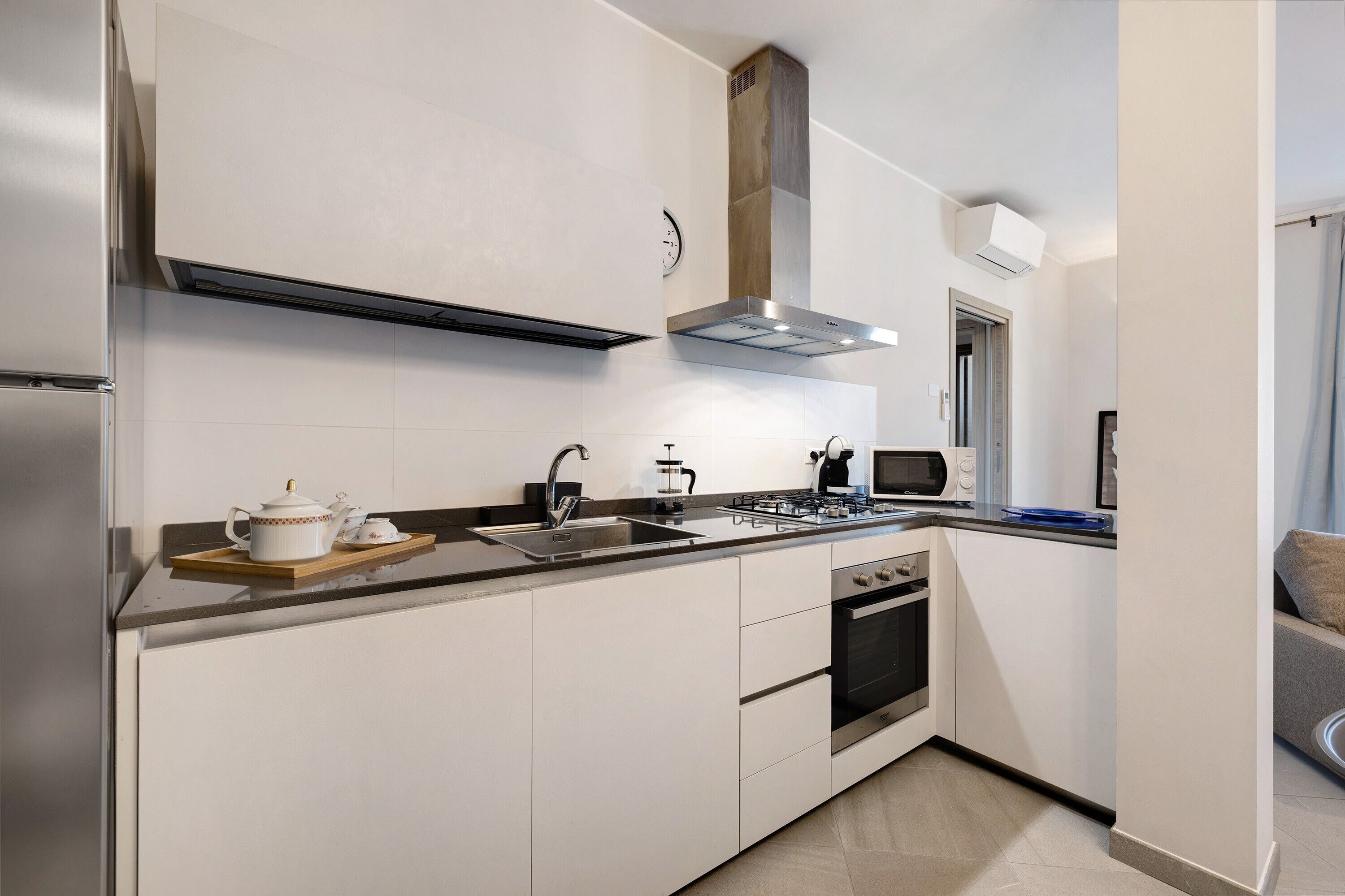 Una cocina moderna con horno empotrado, microondas y estufa a gas.