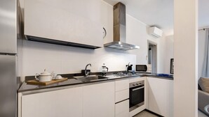 A modern kitchen with a built-in oven, microwave, and gas stove. - Vacation Apartment '4 Passi Mare 2' with Balconies, A/C and Wi-Fi (Finale Ligure)