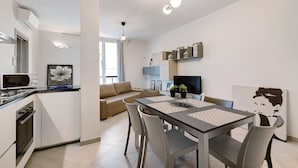A modern kitchen with a dining area, a sofa, and a TV. - Vacation Apartment '4 Passi Mare 2' with Balconies, A/C and Wi-Fi (Finale Ligure)