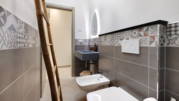 Ein Badezimmer mit Waschbecken, Spiegel und Toilette.