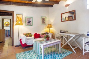 Un salon confortable avec un canapé, deux lampes, une table et un miroir.