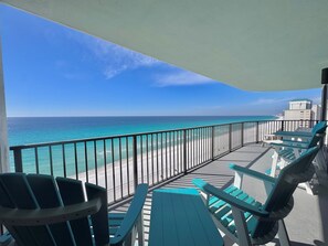 A balcony with a view of the beach and ocean.