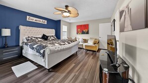 A bedroom with a bed, a sofa, a TV, a ceiling fan, and a wall with a motivational quote. - The Lake Home - Beautiful Oasis In The Heart Of Florida! 2 Bedroom Home by RedAwning (Haines City)