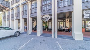 Un edificio de varios pisos con una entrada central, zona de estar al aire libre y un letrero visible que dice 'ME 82 South'.