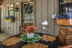 A dining area with a round table, chairs, and a window with a view. - Cliff Haven 1 Bedroom Cabin by RedAwning (Townsend)