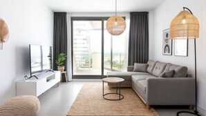 A modern living room with a grey sofa, a TV, a small table, and a floor lamp. - Marinsa Beach II Sea View/Roof terrace by Interhome (Torrox Costa)