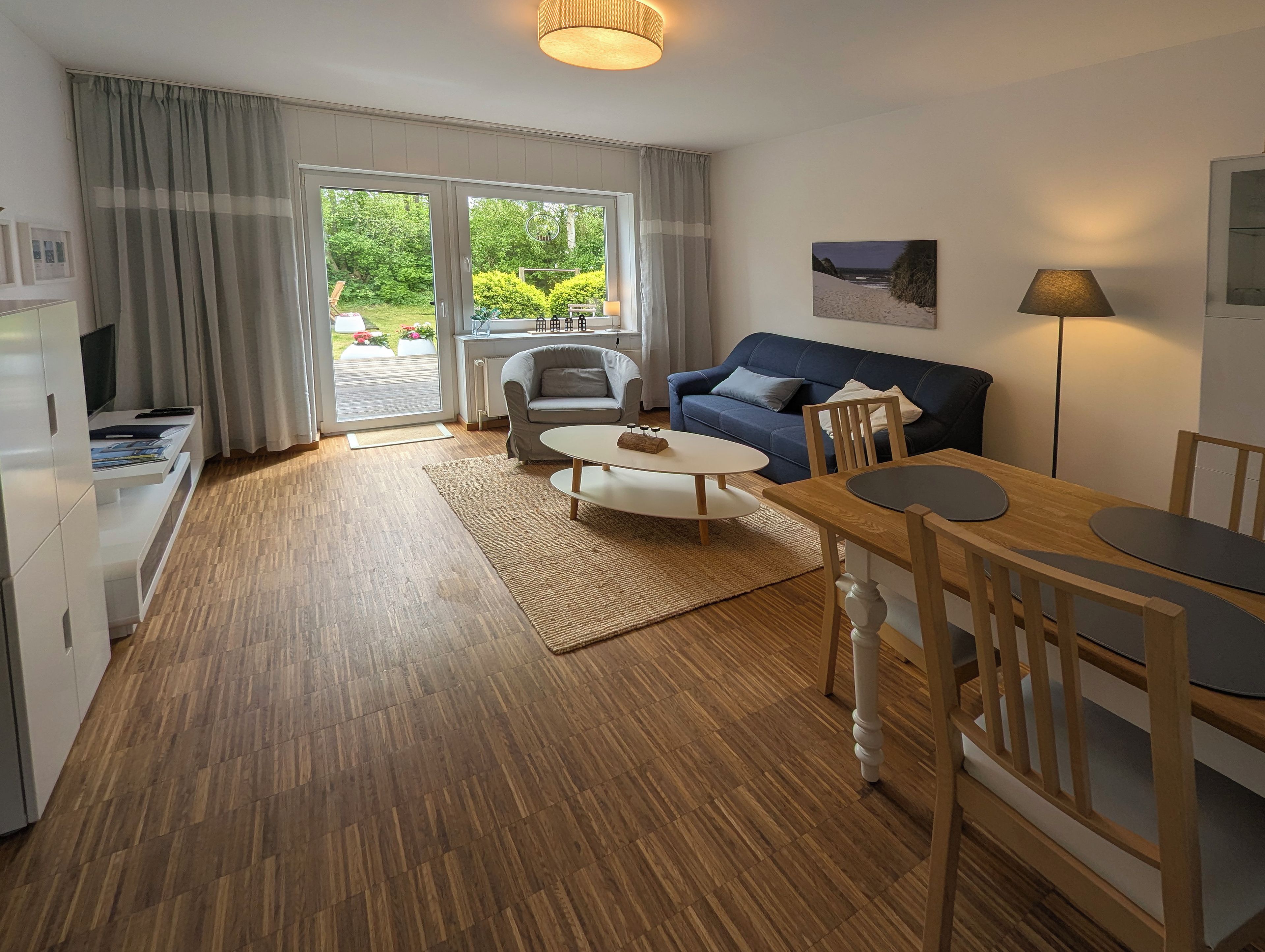Een moderne woonkamer met een bank, salontafel en een eethoek.