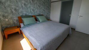 Ein Schlafzimmer mit einem Bett, Nachttischen und einem Kleiderschrank.